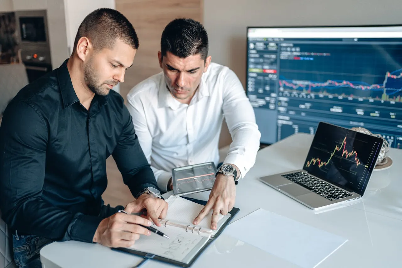 two fia acca qualified employees with high acumen analysing market trends and graphs