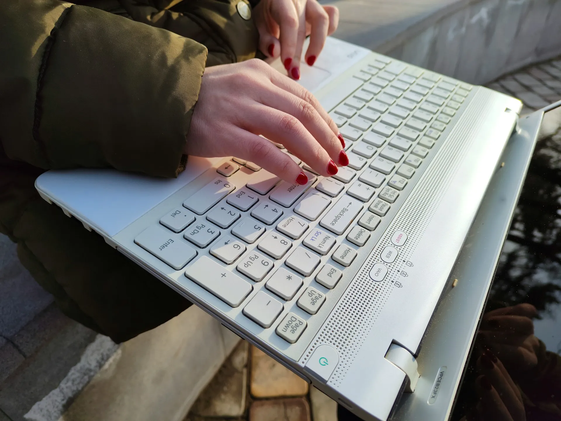 A close-up of a person typing on a laptop during an online assessment
